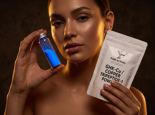 Model holding Pure Actives GHK-Cu Copper Tripeptide-1 Powder pouch and blue vial with dramatic golden lighting